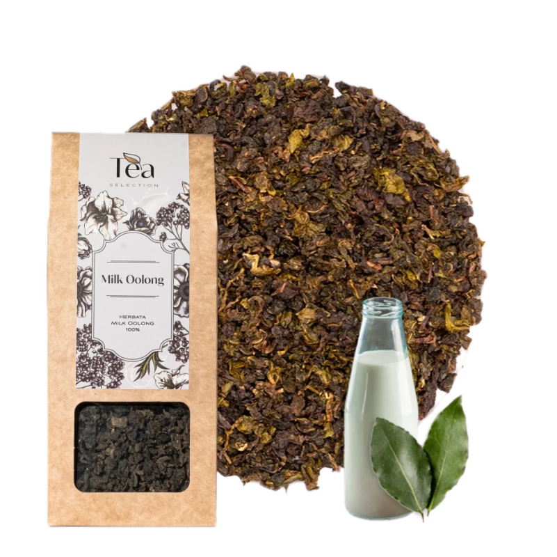 Opakowanie herbaty Milk Oolong obok filiżanki herbaty z liśćmi herbaty i mlekiem w tle. Etykieta zawiera nazwę herbaty i składniki.