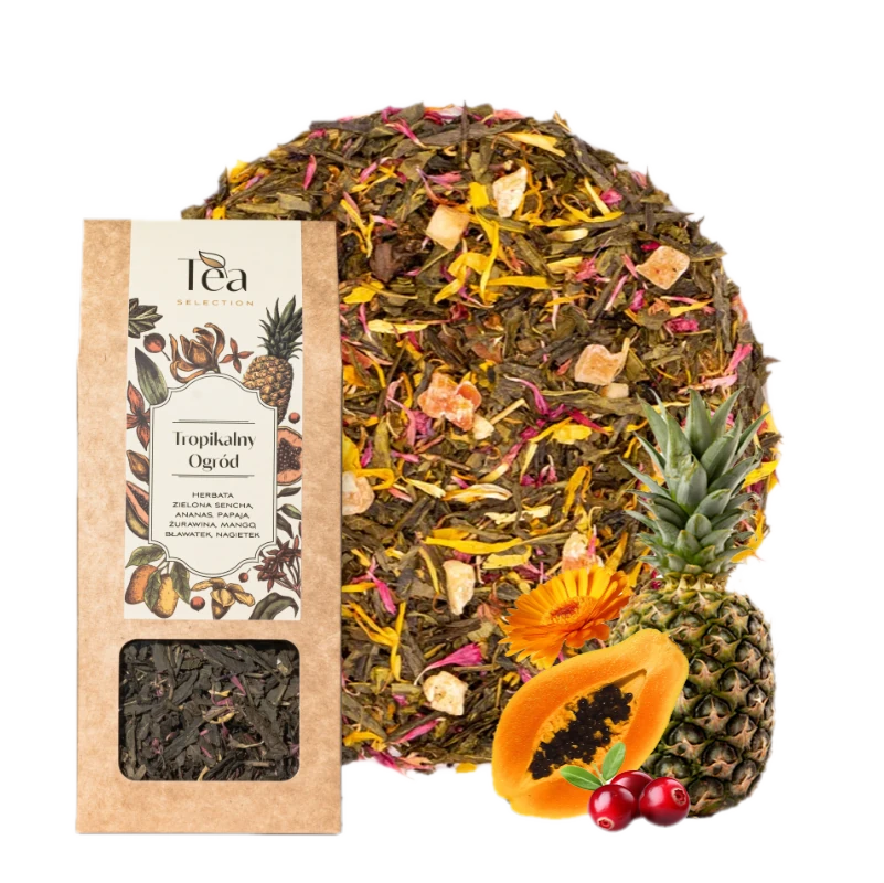 Opakowanie herbaty Tropikalny Ogród obok miski z mieszanką herbaty zawierającą kawałki ananasa, papai, żurawiny i płatki kwiatów. Etykieta zawiera nazwę herbaty i składniki.