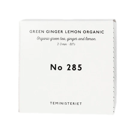 Opakowanie herbaty Teministeriet No 285 Green Ginger Lemon Organic, zawierającej organiczną zieloną herbatę, imbir i cytrynę. Idealna do zaparzania w temperaturze 80°C przez 2–3 minuty. Pudełko w eleganckim, minimalistycznym stylu, białe z czarnymi napisami, charakterystyczne dla marki Teministeriet.